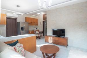 een keuken en een woonkamer met een bank en een televisie bij Διαμέρισμα με αυλή στη Μέλισσα in Xanthi