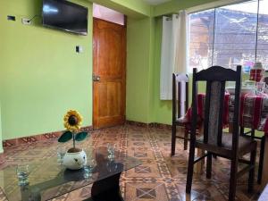 ein Wohnzimmer mit einem Tisch, Stühlen und einem Fenster in der Unterkunft Julio Reyna Apartamento in Cusco