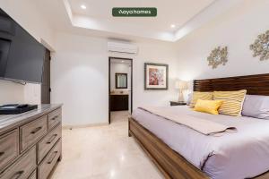 a bedroom with a large bed and a flat screen tv at Copala at Quivira 5302 in Cabo San Lucas
