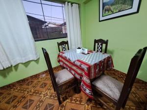 ein Esszimmer mit einem Tisch mit Stühlen und einem Fenster in der Unterkunft Julio Reyna Apartamento in Cusco
