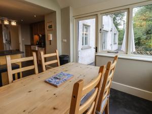 a kitchen and dining room with a wooden table and chairs at Foxdene Cottage in Underbarrow