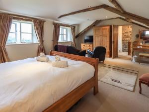 a bedroom with a large bed with two towels at Foxdene Cottage in Underbarrow