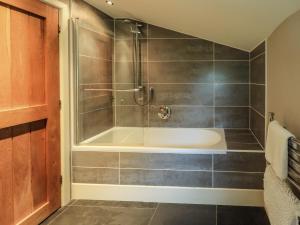 a bathroom with a tub and a shower at Foxdene Cottage in Underbarrow +38 photos