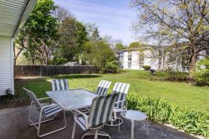 een patio met een tafel en stoelen in een tuin bij Peaceful Suburb Home mins from RIT/Airpt/DWTN in Henrietta