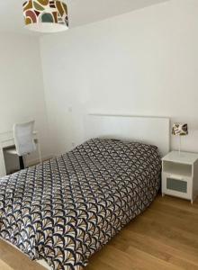 a bedroom with a bed and a table with a lamp at Very nice 40m quiet with parking space in Suresnes