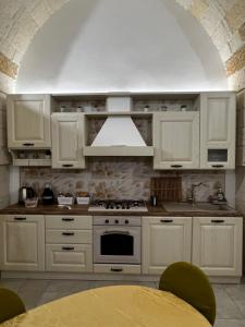 una cucina con armadi bianchi e piano cottura di Il Bassotto a Brindisi