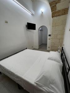 ein Schlafzimmer mit einem großen weißen Bett in einem Zimmer in der Unterkunft Il Bassotto in Brindisi