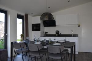 a dining room with a black table and chairs at 6 persoons bungalow met omheining van de tuin vlakbij Walibi in Biddinghuizen