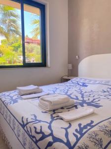 a bed with towels on it with a window at Rais Gerbi Appartamento in Pollina