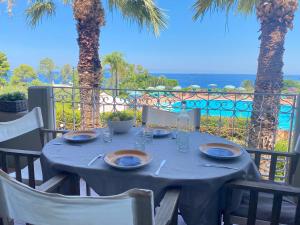 a table with a blue table cloth on a balcony with palm trees at Rais Gerbi Appartamento in Pollina