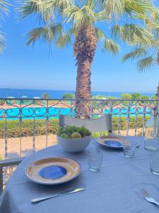 a table with a bowl of fruit and a palm tree at Rais Gerbi Appartamento in Pollina