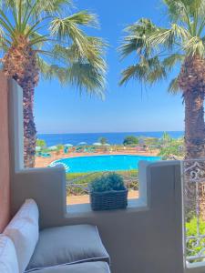 a living room with a couch and palm trees at Rais Gerbi Appartamento in Pollina