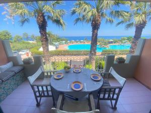 a balcony with a table and chairs and a view of a pool at Rais Gerbi Appartamento in Pollina +26 photos