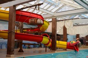 um parque aquático com vários escorregas e uma piscina em 6 persoons bungalow met omheining van de tuin vlakbij Walibi em Biddinghuizen