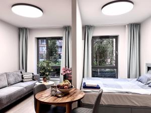 a bedroom with a bed and a couch and a table at Scala Apartments Gdańsk by Acznowy & Parking in Gdańsk