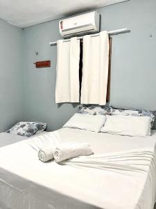 a bedroom with a white bed with towels on it at Pousada Apart Amor de Jeri in Jericoacoara