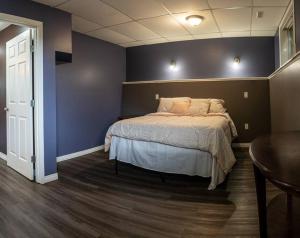 een slaapkamer met een bed en een blauwe muur bij Pink door-ed wonder in Grande Prairie +18 foto's