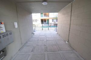 an empty hallway with a tile floor in a building at Hollywood Business Apartments in Los Angeles