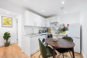 a kitchen with a table and chairs and a refrigerator at Camden Garden Apartments in London