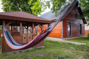 a hammock in a gazebo in front of a house at Domek nad rzeką in Zatory