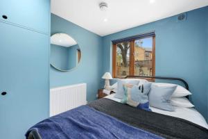 una camera blu con letto e specchio di Camden Garden Apartments a Londra