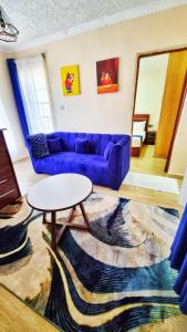 a living room with a purple couch and a table at Crystal Cribs Eldoret in Eldoret