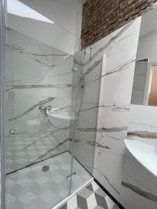 a bathroom with a glass shower and a sink at Florianska Deluxe Apartments with Air Condition in Krakow