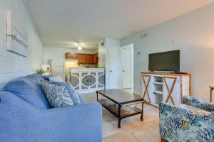 a living room with a blue couch and a tv at Okaloosa Island Condo Near Boardwalk and Beach! in Fort Walton Beach