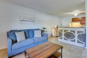 a living room with a blue couch and a table at Okaloosa Island Condo Near Boardwalk and Beach! in Fort Walton Beach