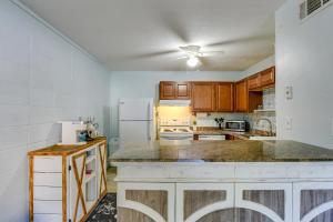 a kitchen with wooden cabinets and a white refrigerator at Okaloosa Island Condo Near Boardwalk and Beach! in Fort Walton Beach +16 photos