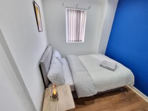 a small room with a bed and a table with a candle at Alluring and hospitable chamber in Liverpool