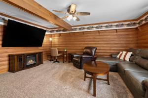 a living room with a couch and a flat screen tv at Fife Lake Lodge 2BR with Kitchen & Lake Views in Fife Lake
