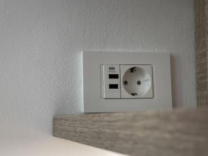 a white lightswitch on a white wall at Studio with a view on City center park in Maribor