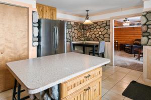 a kitchen with a stainless steel refrigerator and a table at Fife Lake Lodge 2BR with Kitchen & Lake Views in Fife Lake