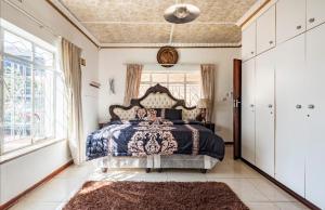 Un dormitorio con una cama grande y una ventana en Whitehouse Lodge, en Benoni