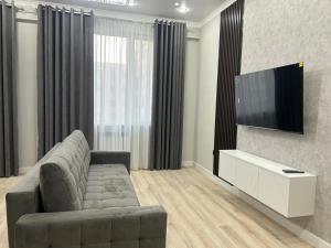 a living room with a couch and a flat screen tv at Квартира в Актау 362 in Aktau