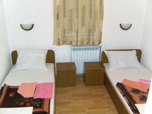 two beds in a small room with a window at Pansion Pero Elez Medjugorje in Međugorje