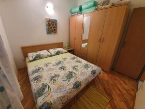 een kleine slaapkamer met een bed en een kast bij Anja in Umag