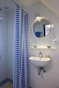 een badkamer met een wastafel en een blauw douchegordijn bij Klein Veers in Kessel
