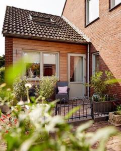 een huis met een veranda met een stoel en een raam bij Klein Veers in Kessel