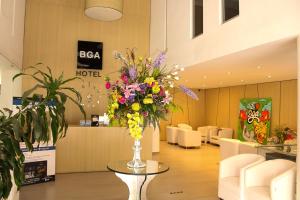 a lobby with a vase of flowers on a table at BGA Hotel in Bucaramanga