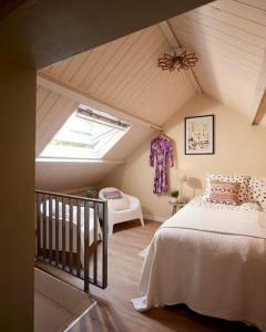 een slaapkamer op zolder met een bed en een dakraam bij Klein Veers in Kessel
