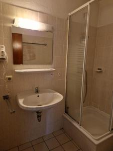 a bathroom with a sink and a shower at Hotel PB in Goslar