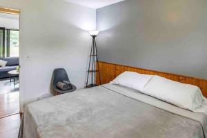 1 dormitorio con cama, lámpara y silla en Enjoyable Home by Airport & Dwtn en Rochester