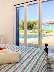 - une chambre avec un lit et une vue sur la piscine dans l'établissement Quinta do Cutato - Piscina Guest House, à Santo Estêvão