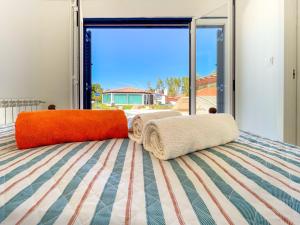 - un lit avec 2 oreillers devant une fenêtre dans l'établissement Quinta do Cutato - Piscina Guest House, à Santo Estêvão