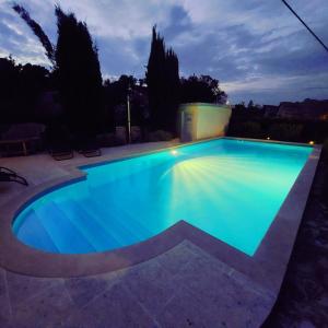 a swimming pool lit up at night at Charming Villa Nika with the pool in Supetar