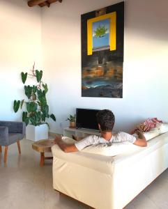 un hombre acostado en un sofá en una sala de estar en Villa Palmeira, en Itacaré
