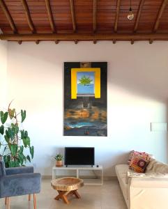 sala de estar con sofá y TV en la pared en Villa Palmeira, en Itacaré