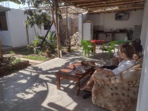 Dos mujeres sentadas en un sofá en un patio en Nomads Club en Nazca